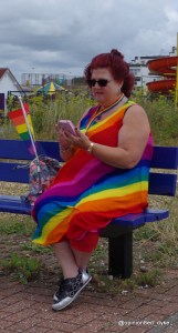 lady on a bench wearing a vivid rainbow dress