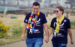 two friends hold hand walking to join Eastbourne Mardi Gras Pride Parade
