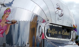 shiny chrome coffee n cakes stall with rainbow flags reflecting